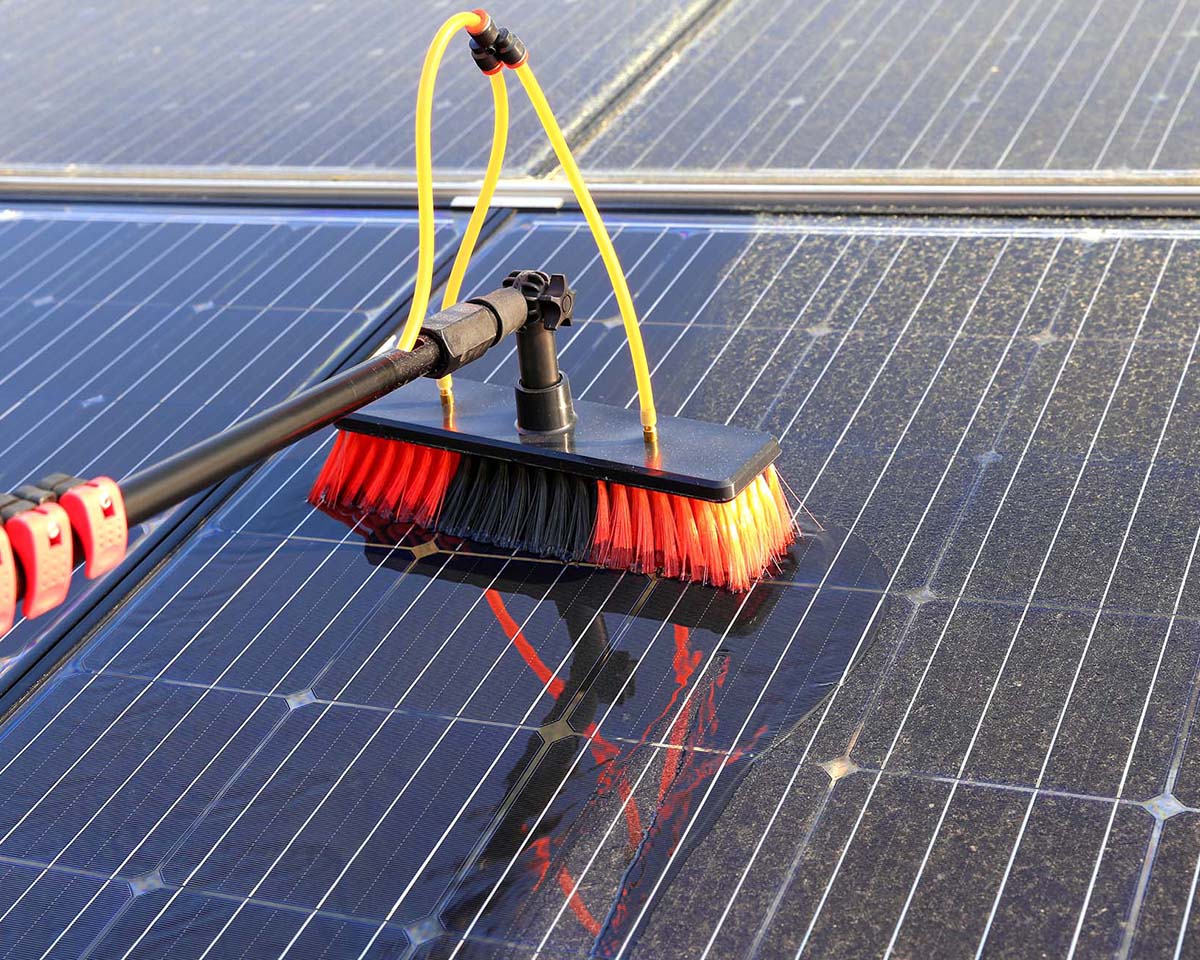 Red and black brush cleaning solar panels